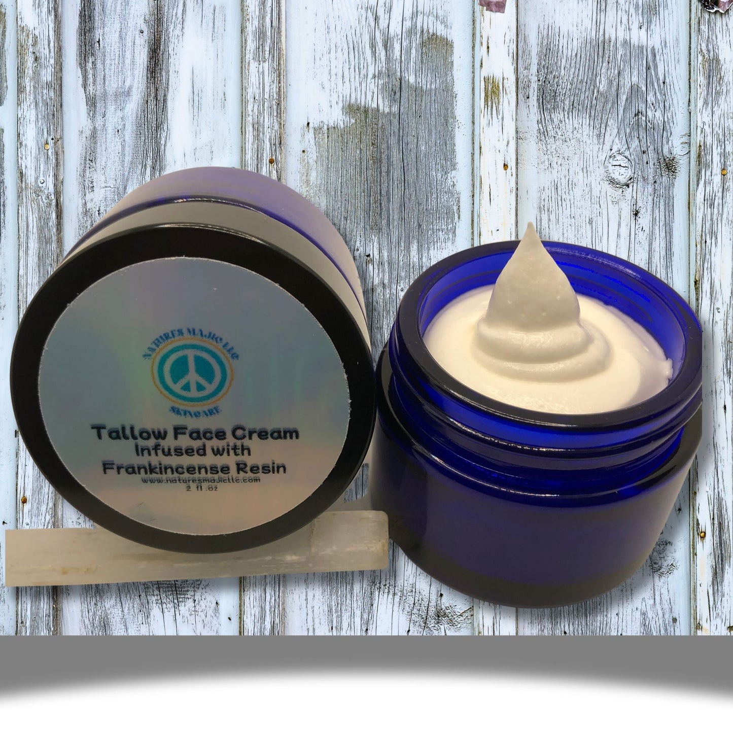 Blue glass jar of Ancient Glow Face Cream with creamy texture, infused with frankincense resin and natural botanicals for skin nourishment and anti-aging benefits.