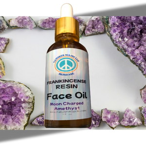Resin Ritual Face Oil with frankincense, black seed, and cold-pressed castor in amber dropper bottle surrounded by amethyst crystals
