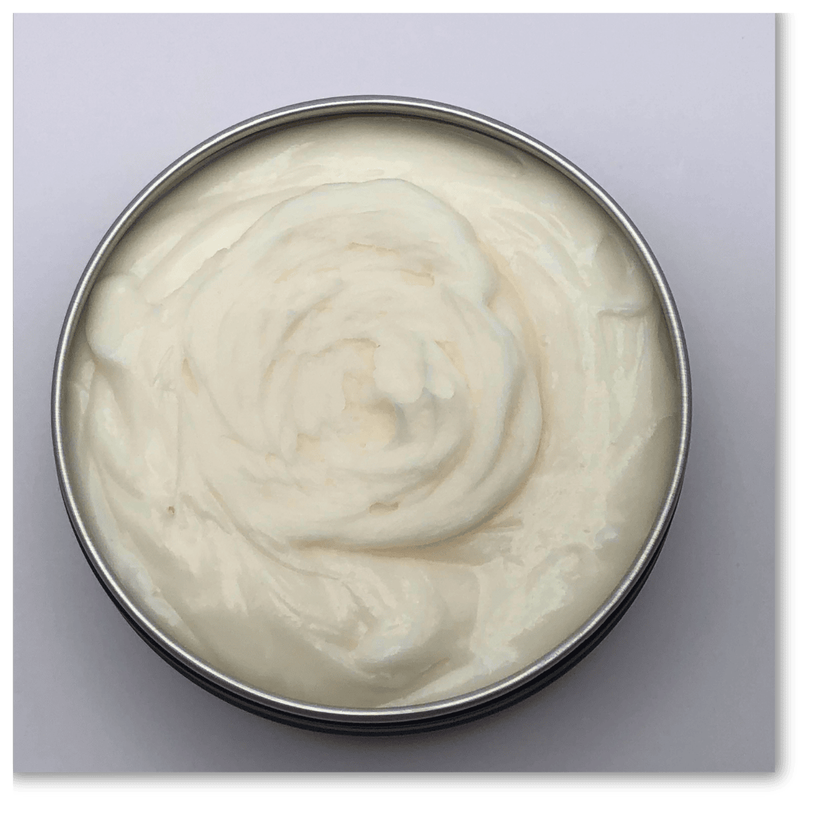 Tallow & Manuka Balm in a round tin, creamy texture for healing, hydration, and sunburn relief.